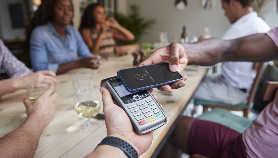 Close Up Of Customer In Restaurant Paying Bill With Contactless Phone App